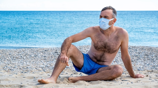 Мужчина в белой медицинской маске на море | Бесплатно Фото