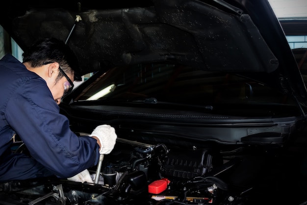 A Mechanic Use Wrench To Repair The Car Engine In The Garage