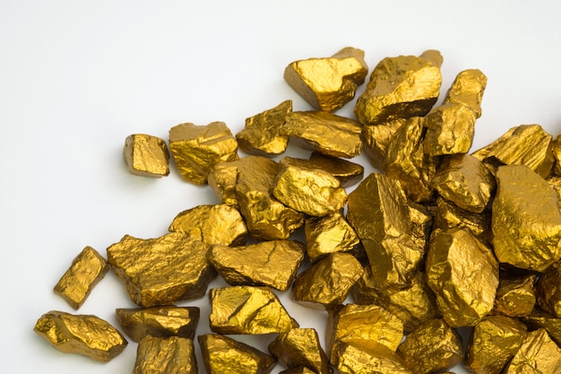金ナゲットや金鉱石の白い背景 貴重な石や金色の石 金融 ビジネスコンセプトの塊の上に分離されての山 プレミアム写真