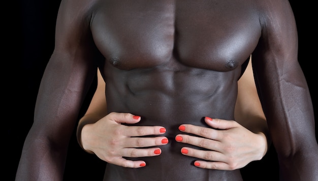 黒人男性の筋肉腹に白人女性の手 プレミアム写真