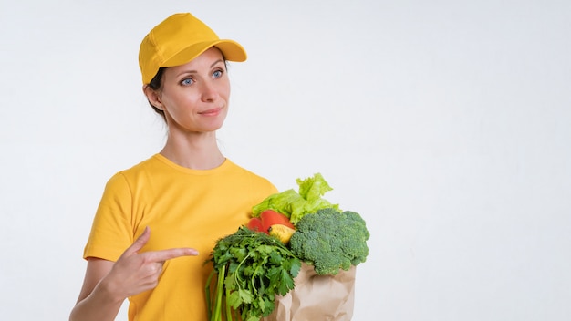 白で食品のパッケージを提供する黄色い服を着た女性 無料の写真