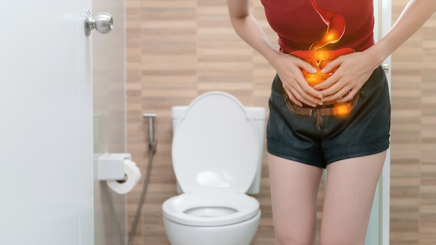 Abdominal pain woman, photo of large intestine on woman body, stomachache diarrhea symptom, menstrual period cramp or food poisoning. health care concept. Premium Photo