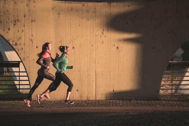 Active girls running at sunset Free Photo