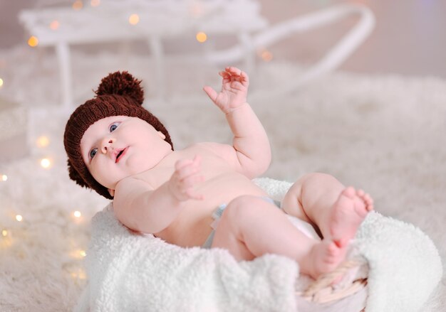 Premium Photo | Adorable baby in brown knitted hat in ...