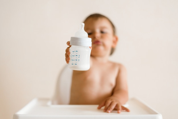 Adorable baby drinking milk from a bottle from bottle ...
