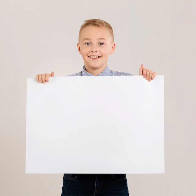 Free Photo | Adorable boy holding blank paper