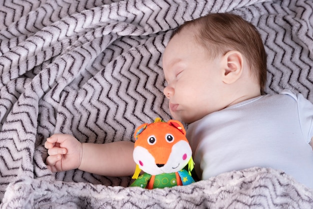 Premium Photo Adorable Child With A Favorite Toy Sleeps Relaxed And Sprawls On The Parents Bed