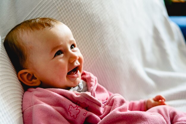 ピンクのパジャマを浮かべて愛らしい面白い赤ちゃん女の子 プレミアム写真