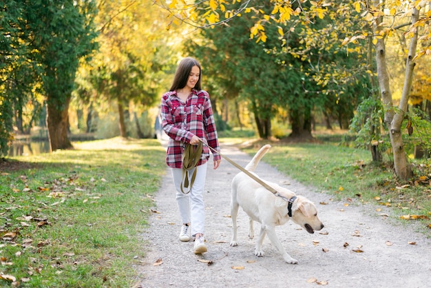 Premium Photo | Adult woman walking in the park with her dog