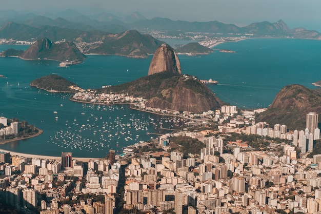 ブラジルの日光の下で海と丘に囲まれたリオデジャネイロの航空写真 無料の写真