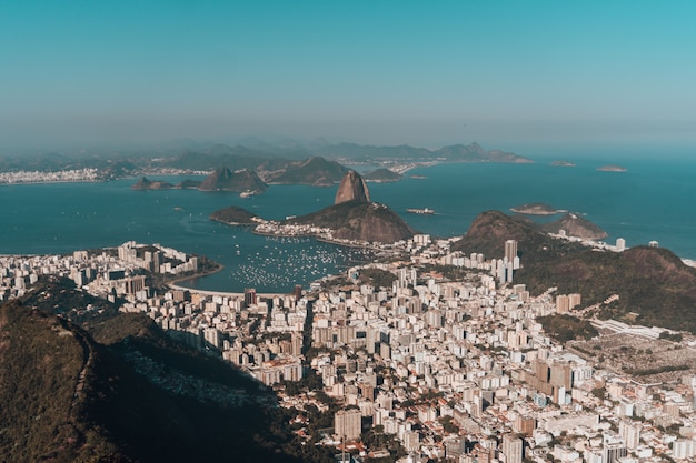 Aerial photo of rio de janeiro surrounded by hills and the sea under a blue sky in brazil Free Photo