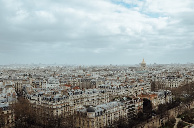 フランスの曇り空の下で緑と建物に覆われたパリの航空写真 無料の写真
