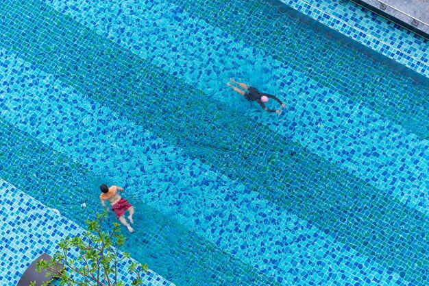 男とプールで泳いでいる少年 水で遊ぶの空中のトップビュー プレミアム写真