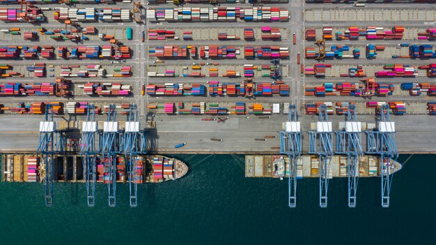 Aerial view cargo ship terminal, unloading crane of cargo ship terminal. Premium Photo
