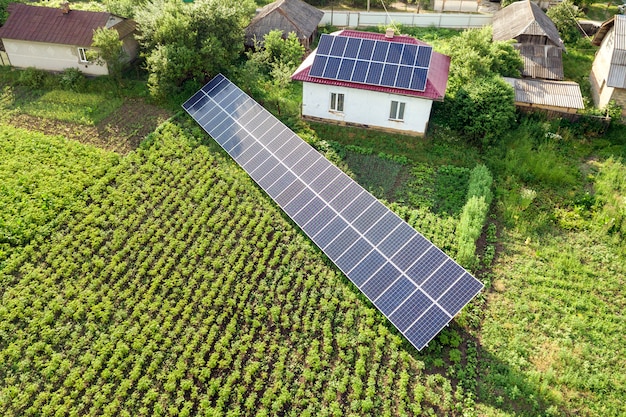 Premium Photo | Aerial view of a house with blue solar panels.