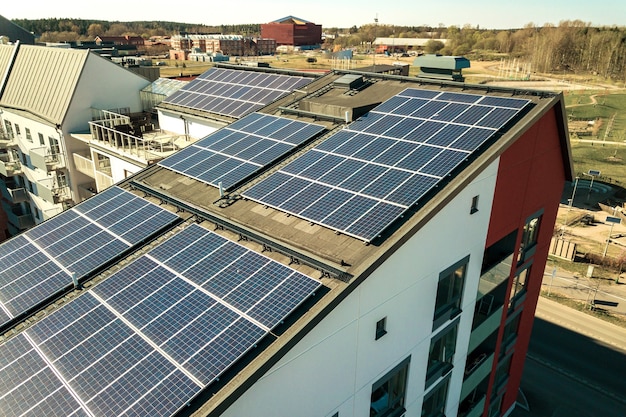 Aerial view of solar photovoltaic panels on a roof top of residential building block for producing clean electric energy. autonomous housing concept. Premium Photo