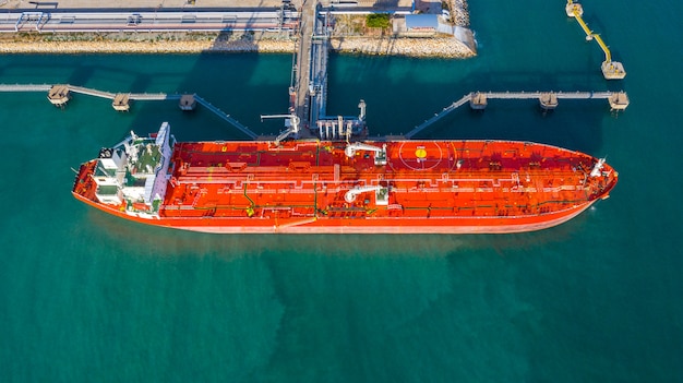 Aerial view tanker ship unloading at port, business import export oil with tanker ship transportation oil from refinery on the sea. Premium Photo