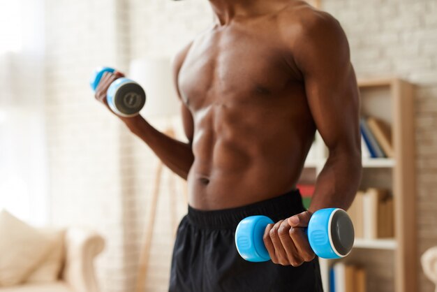 ダンベルで筋肉をポンピングするアフリカ系アメリカ人の運動選手 プレミアム写真