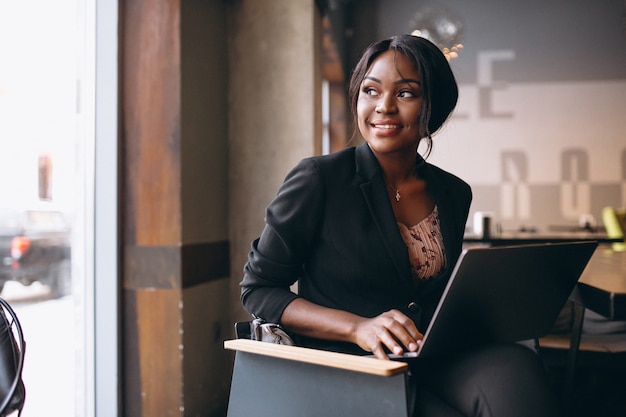 African american business woman working on a computer in a bar ...