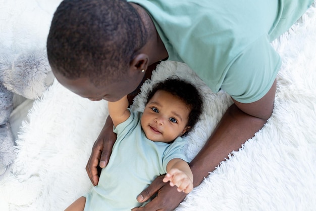 Premium Photo | African-american dad and baby son talking or cuddling ...