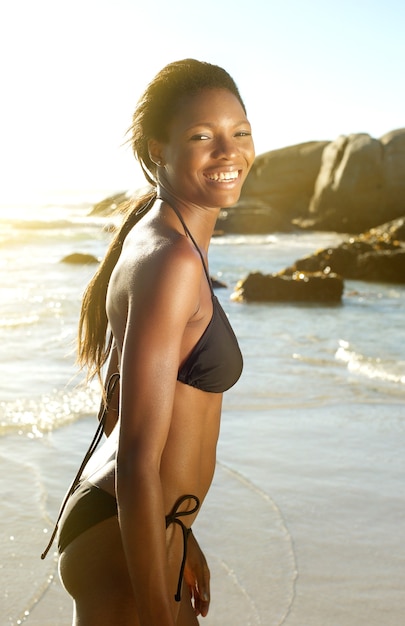 ビーチで笑うビキニのアフリカ系アメリカ人女性 プレミアム写真