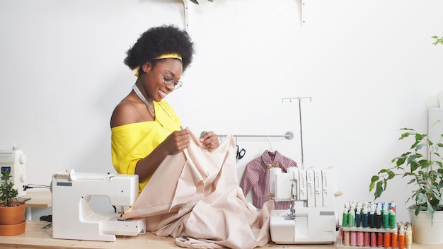 Premium Photo | African-american woman sews clothes in her favorite ...