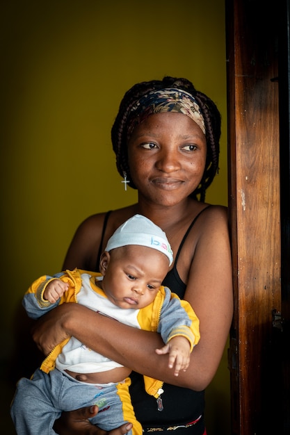 Premium Photo | African american young mother holding her baby indoors