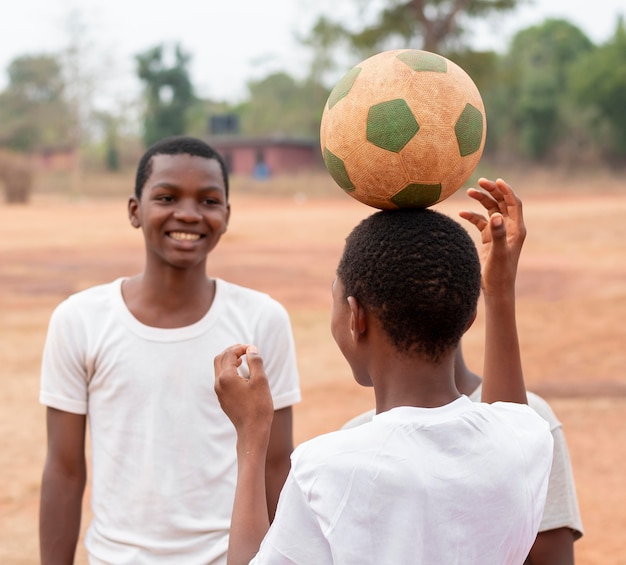 サッカーボールを持つアフリカの子供たち プレミアム写真
