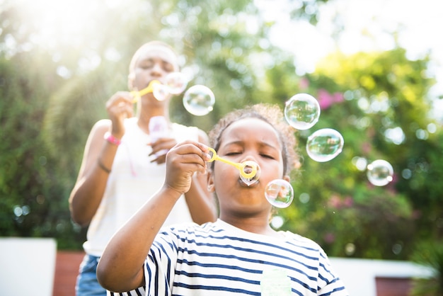 Premium Photo | African descent girl blowing bubbles outdoor