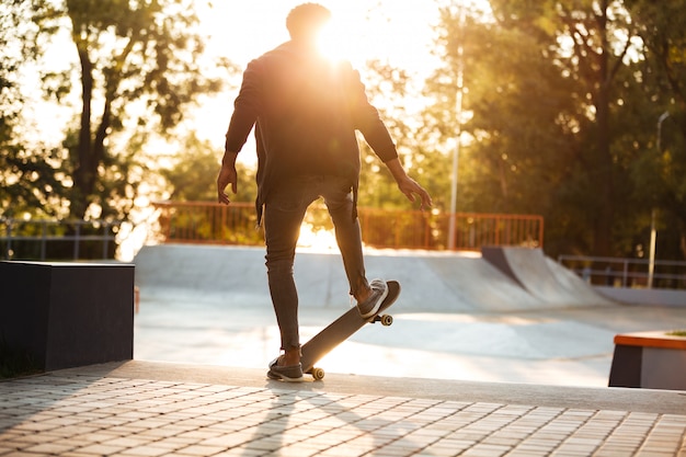 African skateboarder skating on a concrete skateboarding ramp | Free Photo