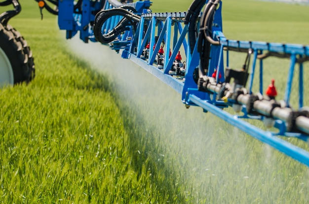 Agricultural sprayers, spray chemicals on young wheat. Premium Photo
