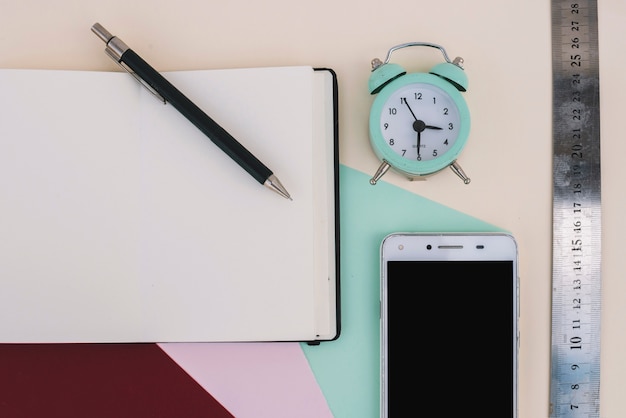 Alarm clock and ruler near smartphone and notebook Free Photo Alarm clock and ruler near smartphone and notebook Free Photo