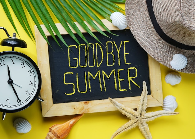 Alarm clock, starfish, fedora hat, palm leaf, sea shells and blackboa Premium Photo