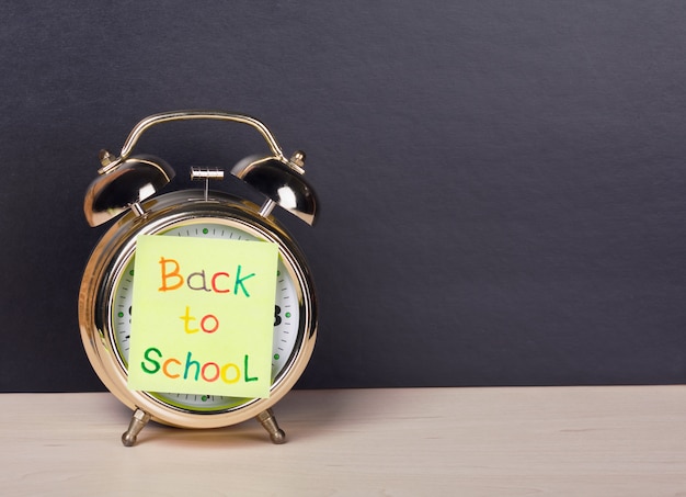 Premium Photo | Alarm clock and sticker with text "back to school"