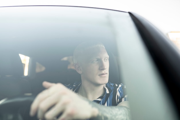 Premium Photo | Albino blond young man driving car