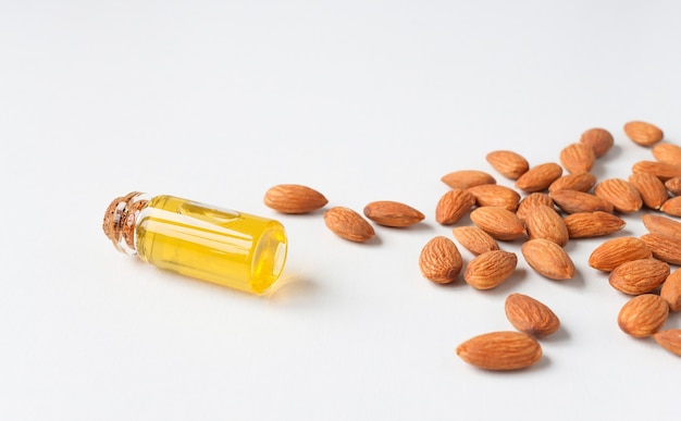 Premium Photo Almond Oil In A Bottle With Scattered Almonds