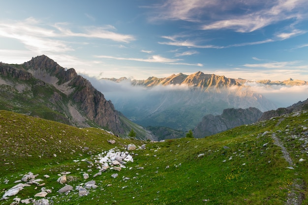 Alpine meadow and pasture set amid high altitude mountain range at sunsets Premium Photo