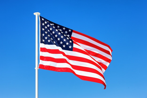 American flag waving in blue sky Free Photo