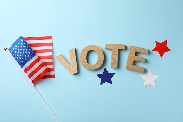 Premium Photo | American flag, word vote and stars on blue surface