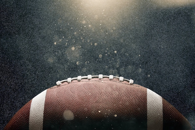 Premium Photo | American football ball on black background illuminated