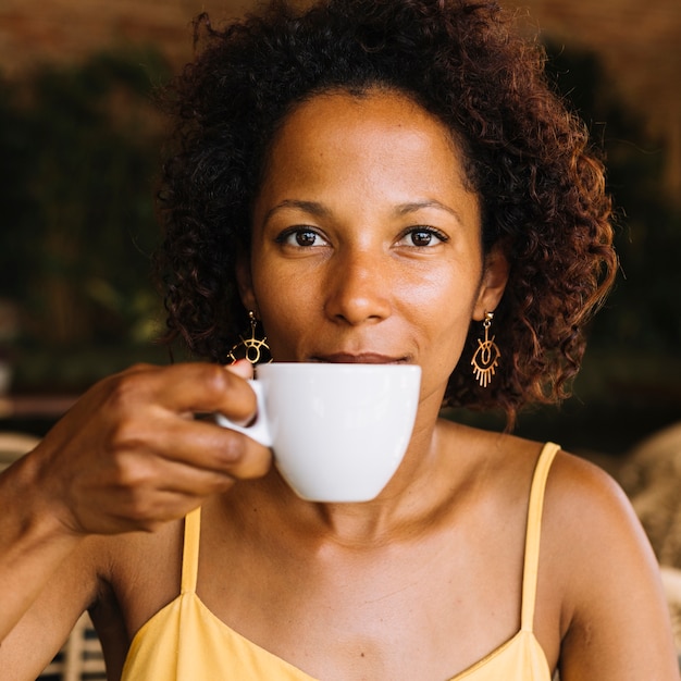 コーヒーを飲むアフリカ系アメリカ人の若い女性 無料の写真