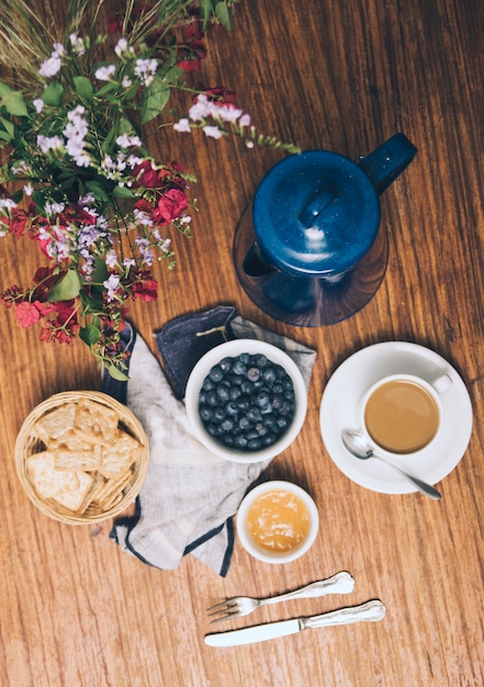花瓶の上から見た図 ブルーベリー クラッカージャム コーヒーカップと木製の背景上のティーポット 無料の写真