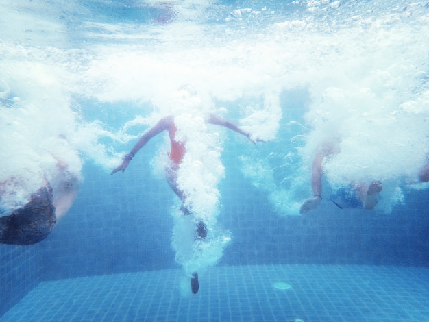 スイミングプールに飛び込む人々のグループの水中撮影 無料の写真
