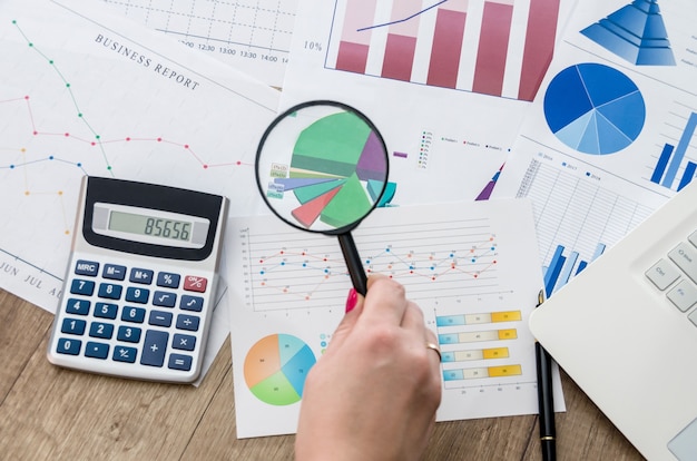 Premium Photo | Analysing business graphs with magnifying glass