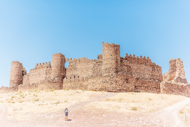 Premium Photo | Ancient walled castle on a hill with a woman standing ...