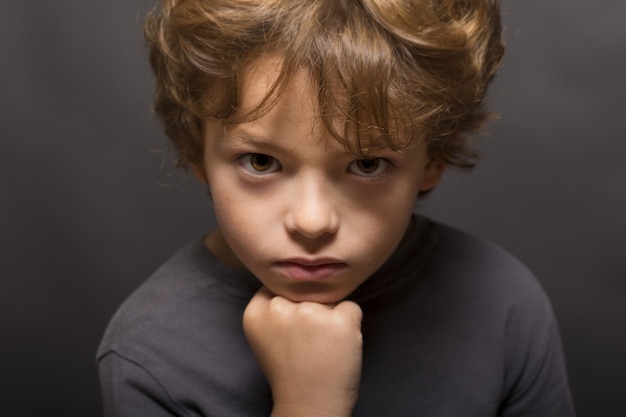 Premium Photo | Angry boy portrait on dark background.