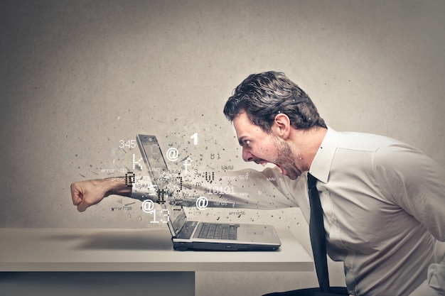 Angry businessman crushing his laptop Premium Photo