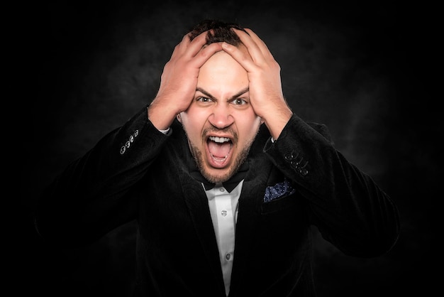 Premium Photo | Angry businessman shouting or screaming over dark ...