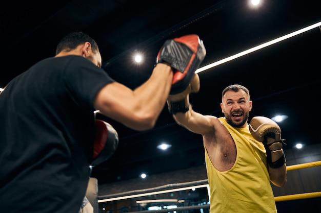 Premium Photo | Angry champion attacking a boxing focus pad on the hand ...