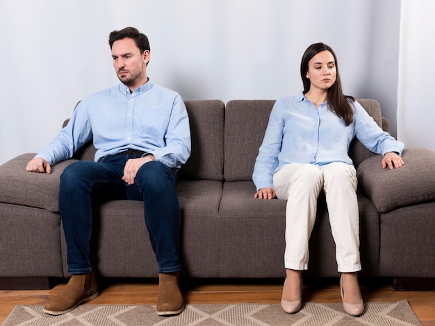 怒っている男性と女性がソファに座って 無料の写真